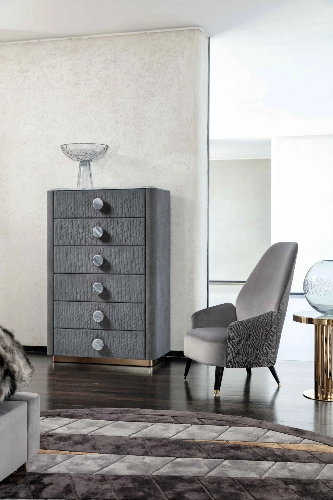 Tall chest in quilted grey with a gold-tone steel base, luxury living furniture